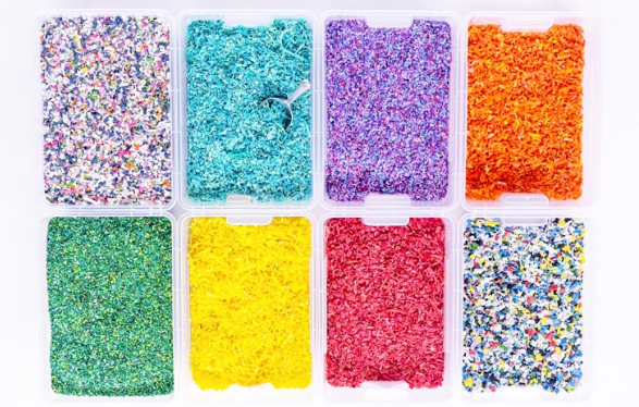 8 bacs de paillettes de plastique triées par couleurs : entre autre du bleu, violet, orange, vert, jaune et rose